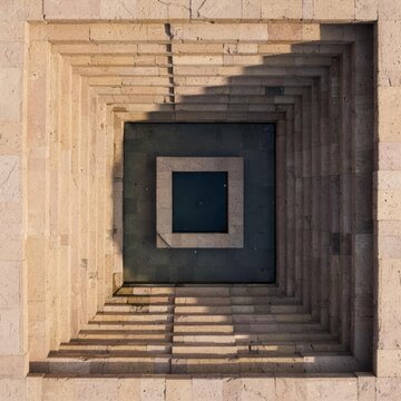 Ancient sandstone stepwell aerial symmetry with central dark pool