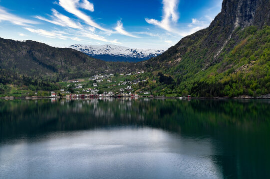 Scenic Norwegian Fjord Village With Snow Capped Mountains, Forested Cliffs and Calm Water Reflections on the Cruise Route to Stavanger Norway