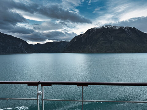 Moody Norwegian Fjord View From Cruise Ship Deck With Mountains and Cloudy Sky