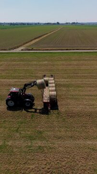 Tractor Gathering Hay Bales aerial view