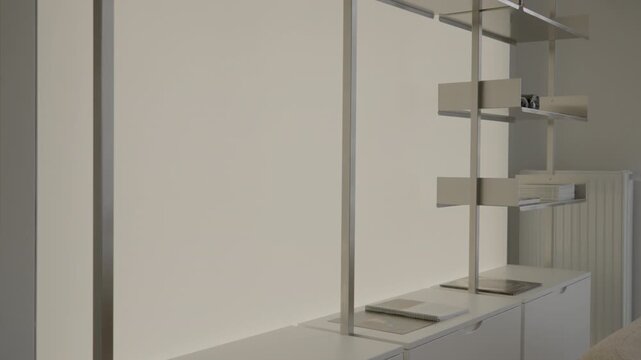 Minimalist shelving unit with integrated LED backlight turns off inside a turnkey apartment, presenting modern custom furniture design for real estate home staging and property renovation.