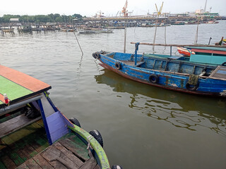 Obraz premium Traditional fishing boats at Lumpur Harbor with industrial factory background