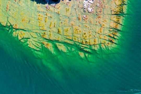 Aerial view of Jamaica Beach with its unique flat rock formations and turquoise water in Sirmione, Lombardia, Italy.