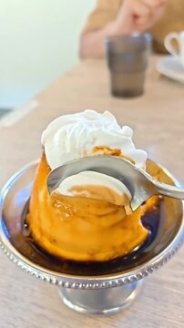 Spoon picking creamy vanilla custard pudding with caramel sauce and whipped cream, French Japanese Bakery Dessert, Milk Egg Sweet Confectionery