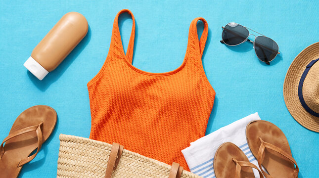 Flat lay photography of summer vacation essentials on vibrant cyan blue background