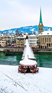 Snowy Zurich cityscape with church steeple.