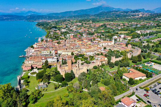 Aerial view of the Scaligero Castle and the historic town of Lazise on the shores of Lake Garda with medieval walls and lush gardens Provincia di Verona, Veneto, Italy.