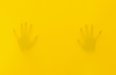 Obraz premium Silhouettes Of Hands And A Kid Behind Yellow Fabric