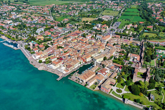 Aerial view of the historic town of Lazise featuring the Scaligero Castle and harbor along the turquoise shores of Lake Garda, Lazise, Veneto, Italy.