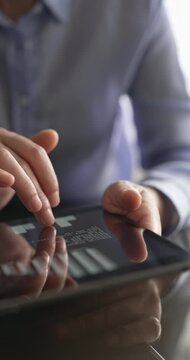 Reviewing financial data on tablet in office
