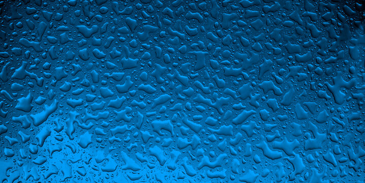 Close-up abstract background of rain drops on glass illuminated with deep blue light, perfect for weather concepts, digital design, wallpapers, banners and modern textures