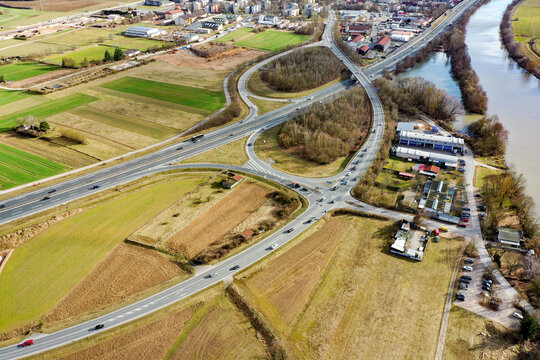 Aerial view of the highway interchange and surrounding green fields near the Regnitz river in Buttenheim, Bavaria, Germany.