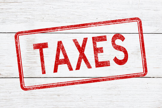 Red distressed Taxes stamp on weathered wood for taxation and IRS
