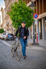 Fototapeta premium Confident bald man with his bicycle in the city