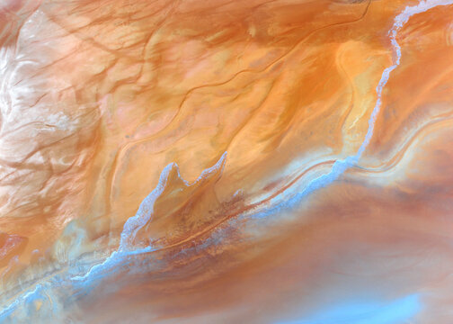 Aerial view of the vibrant orange mineral deposits and swirling textures of the Minas de Riotinto mining area in Minas de Riotinto, Andalusia, Spain.