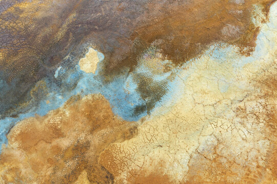 Aerial view of the colorful mineral deposits and cracked earth textures of the open pit mines in Minas de Riotinto, Andalusia, Spain.
