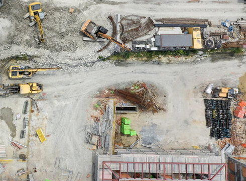Aerial view of a busy construction site featuring excavators, rebar piles, and building materials in Sariyer, Istanbul, Turkiye.