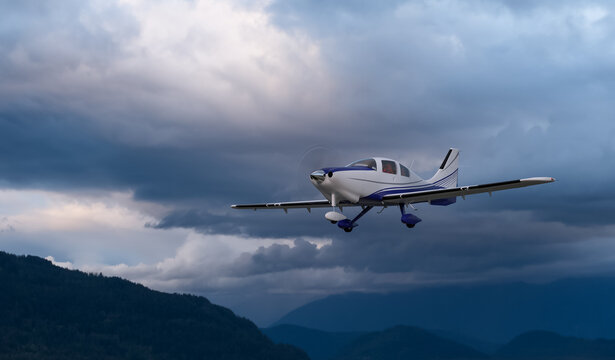 Single-Engine Airplane Flying Over Mountain Valley Under Dramatic Storm Clouds at Dusk