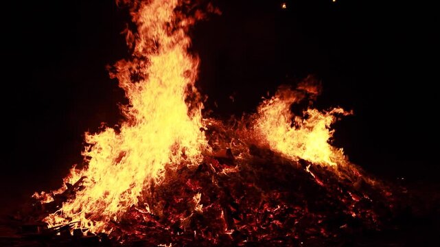 Hoguera ardiendo en la noche con grandes llamas y brasas en c&aacute;mara lenta