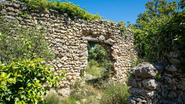 Ancient stone doorway with wooden lintel in deserted Moorish village in Spain under clear blue sky