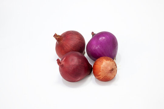 Photographic work of indispensable vegetables of the table, dried onions, garlic and green peppers on a white background.