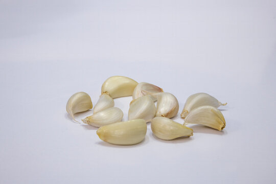 Photographic work of indispensable vegetables of the table, dried onions, garlic and green peppers on a white background.
