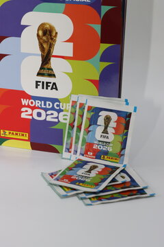 A collection of Panini sticker packets and an album for the FIFA World Cup 2026 tournament, featuring the iconic trophy