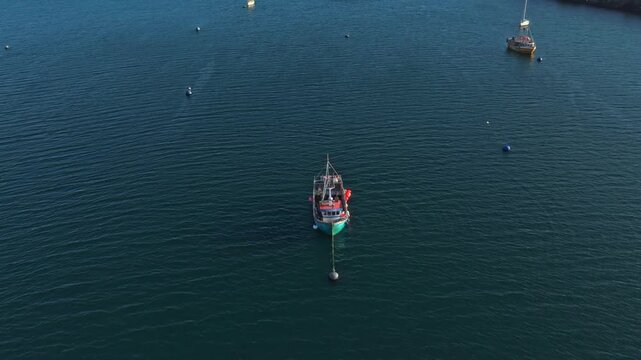Fishing trawler navigating a scottish loch on a sunny day