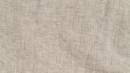 Fototapeta premium Close look at textured fabric with natural fibers in neutral tone during bright daylight