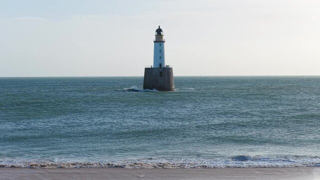 Rising tide submerging a beach with rattray head lighthouse
