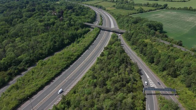 Motorway Traffic Passing Under a Bridge in a Green Countryside Area