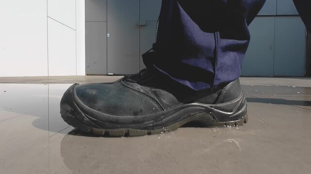 Close Up of Heavy Duty Boots Moving Through Water on Industrial Floor