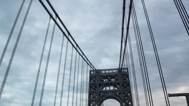 point of view of car driving over george washington bridge between fort lee new jersey and manhattan york heights (sunset night time cloudy suspension bridge)