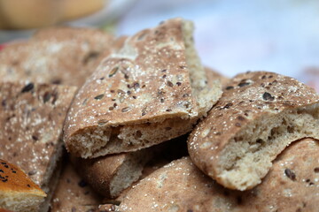 Fototapeta premium Macro close-up of traditional Moroccan whole wheat flatbread (Khobz) wedges with mixed seeds
