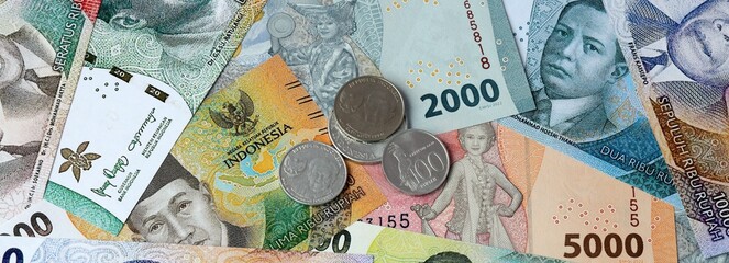Indonesian rupiah money banknotes and coins on table. Indonesia cash bills of IDR currency © Viktor