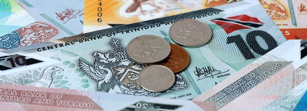 Trinidad and Tobago dollar money and coins on table. Trinidad and Tobago cash bills of TTD currency