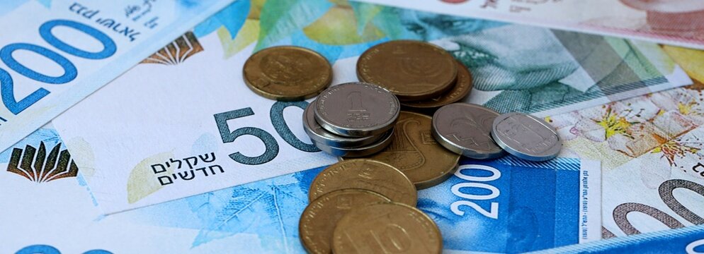 Israeli shekel money banknotes and coins on table. Israel cash bills of ILS currency