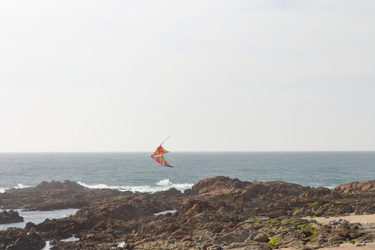 A person parasailing over a rocky beach
