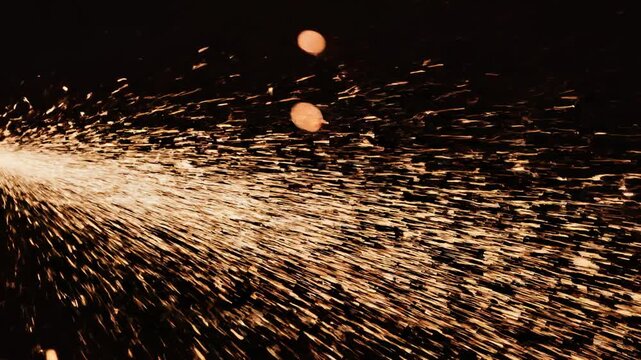 Constant stream of flickering orange sparks blowing from left to right background fire particle video