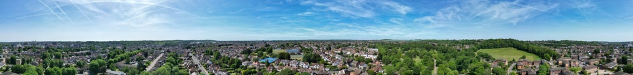 Fototapeta premium High Angle Panoramic View of Residential Homes at Luton City During Hot Weather and Sunny Day. Urban Drone Flight Above Urban City Streets of British City and Town of England Great Britain.