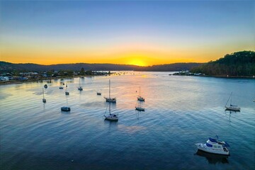 Naklejka premium Aerial sunrise waterscape with boats and clear skies