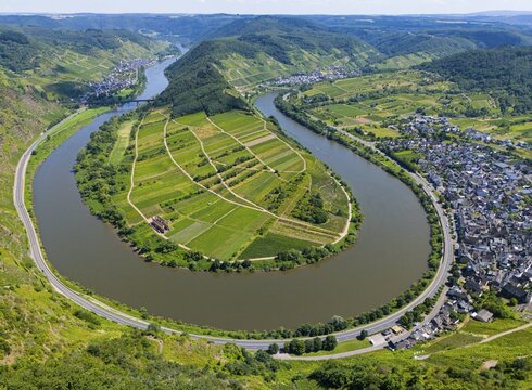 A winding river bend surrounds an agricultural landscape surrounded by hills, with a neighbouring village and vineyards, aerial view, Moselle, Moselle bend, Bremm, Cochem, Cochem-Zell, Rhineland-Palatinate, Germany