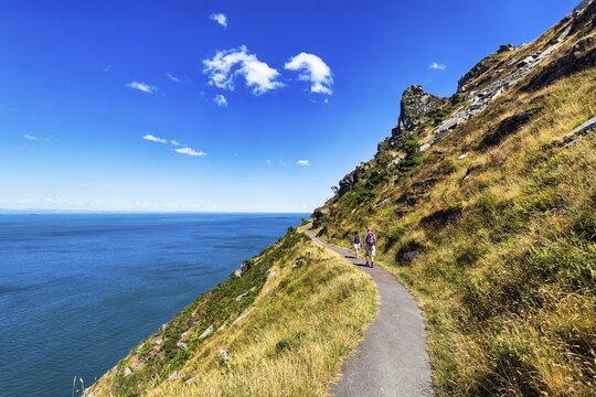 Walkers on South West Coast Path, coastal path, Valley of the Rocks, rocky coast in Exmoor National Park, Bristol Channel, near Lynton, Devon, England, United Kingdom