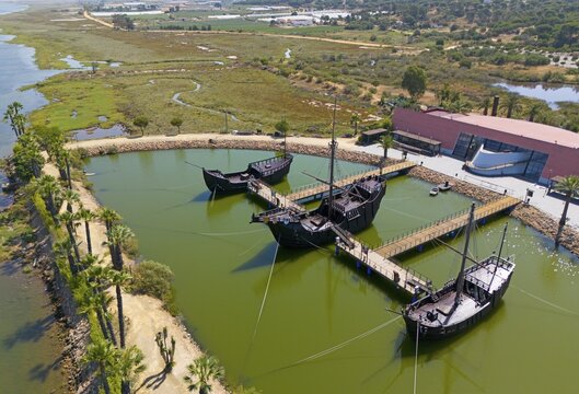 Historically modelled sailing ships in a calm water basin, surrounded by landscape under a clear sky, aerial view, Muelle de las Carabelas, reproductions of La Ni&ntilde;a, La Pinta and La Santa Mar&iacute;a, Museum, Palos de la Frontera, Province of Huelva, Andalusia, Spain