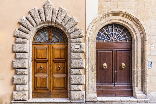 Round arched front doors inlaid with stones and marble, Montepulciano, Tuscany, Italy
