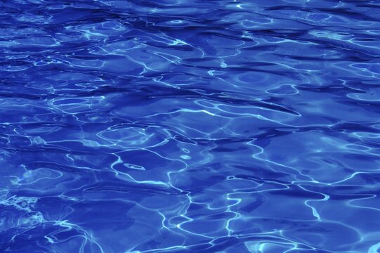 Water surface in a swimming pool with lights reflections