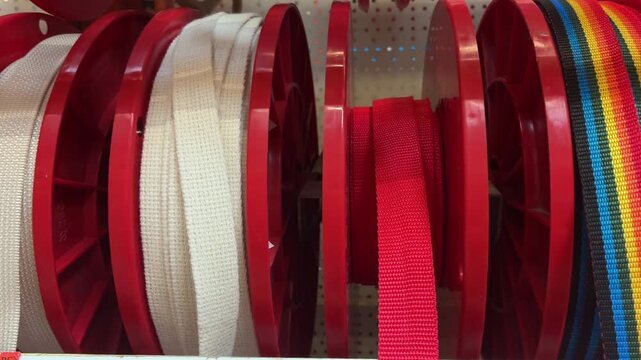 Close-up of colorful sewing fabric thread spools on retail shop shelves