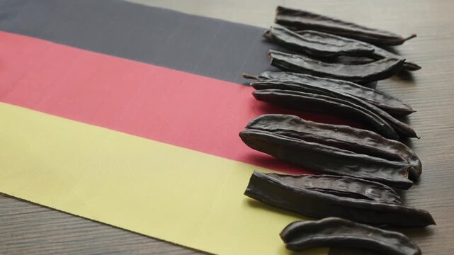 Carob pods and seeds placed on Germany flag