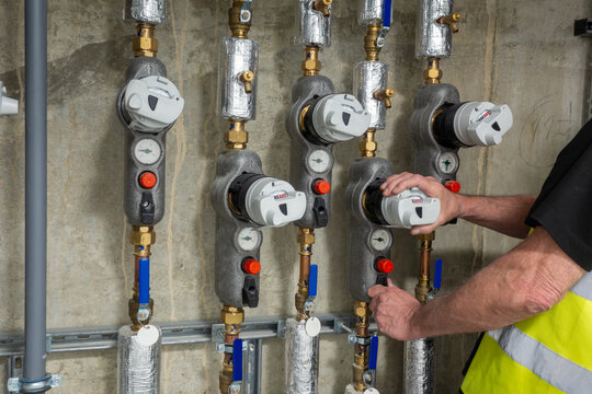 Plumbing engineer investigating a faulty water usage meter. Plumber isolating a water meter to carry out planed preventative maintenance and check that the meter is compliant with water regulations.