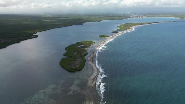 Drone aerial of shallow tropical lagoon with visible sand formations, green mangroves and peaceful coastline at La Cobita in Dominican Republic.